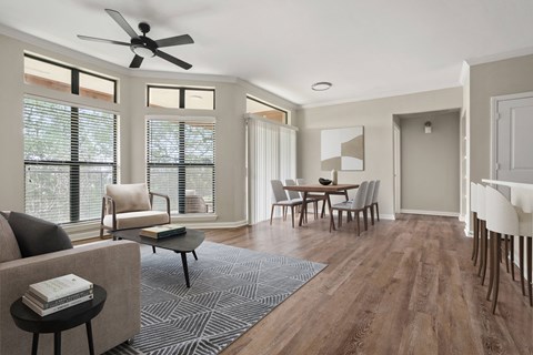 an open living room and dining room with a table and chairs and a ceiling fan